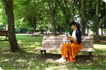 Woman reading a book on a park bench.