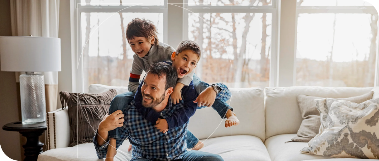 Man playing with 2 small boys in family living room