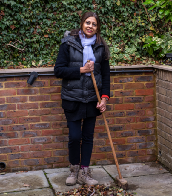 Lady sweeping leaves on patio