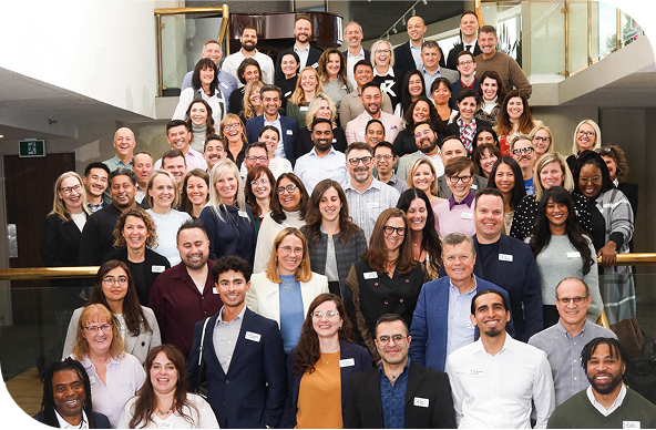 Group shot of UCB employees posing on a large office staircase