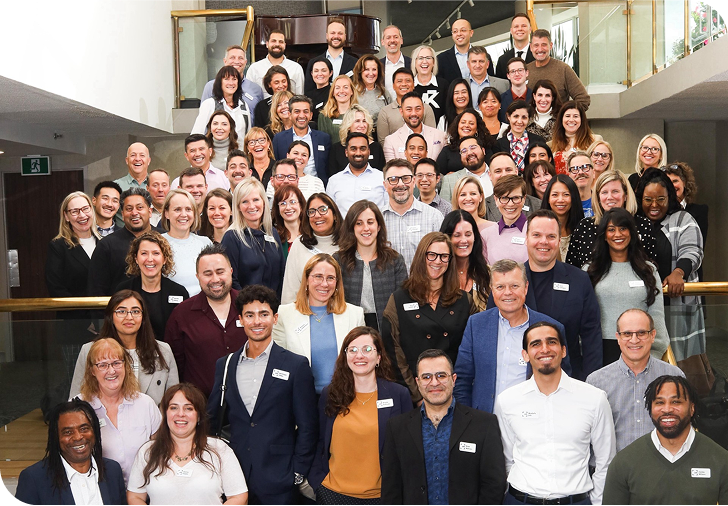 Group shot of UCB employees posing on a large office staircase.